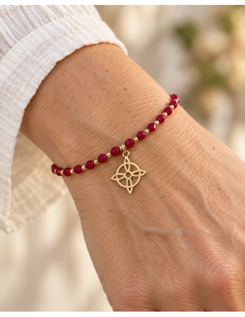 Pulsera roja ajustable con dije circular de cuatro puntas bañada en oro sobre fondo blanco 2